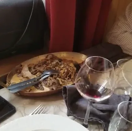 Une assiette servie en salle, avec un verre de vin rouge